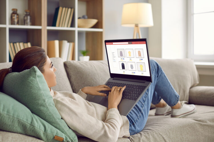 Woman relax on sofa shopping online on laptop