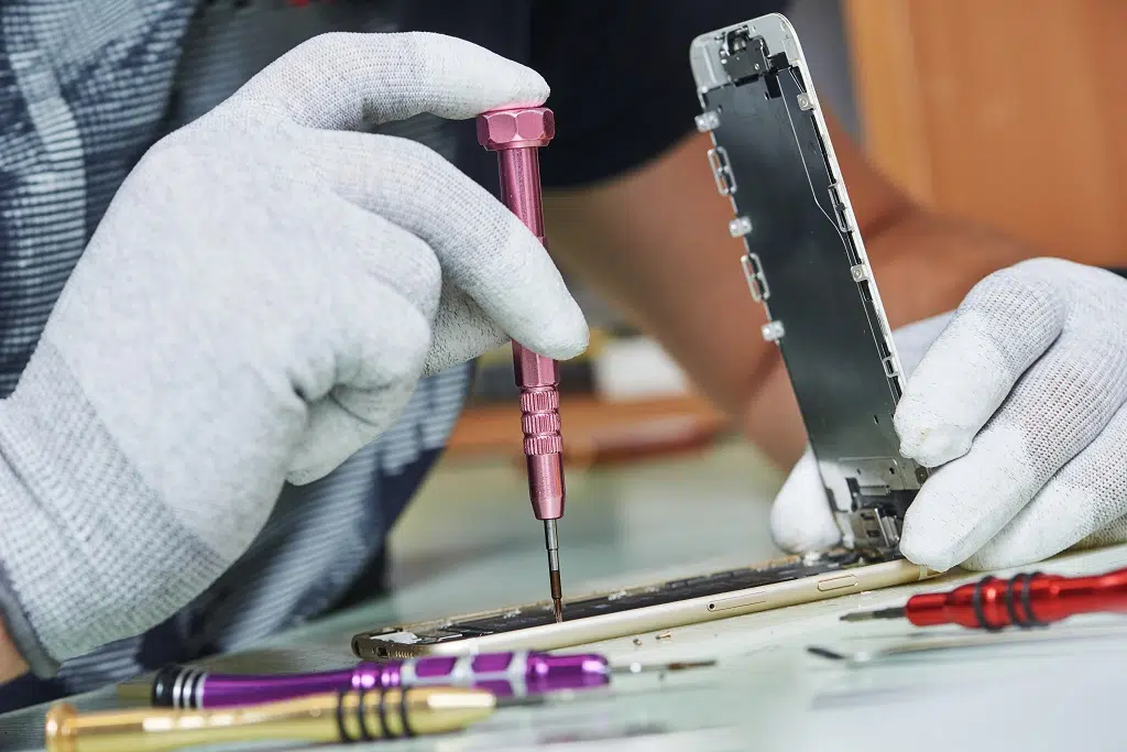 Repairman uses screwdriver  on smartphone