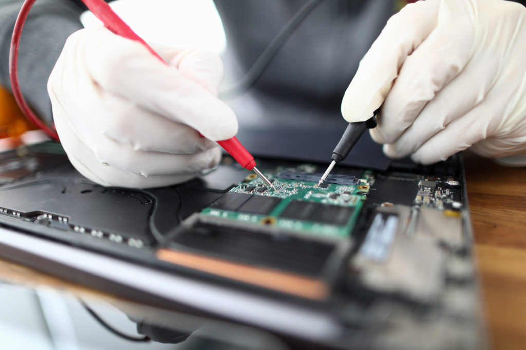 Male hands in white protective glove holding tester device