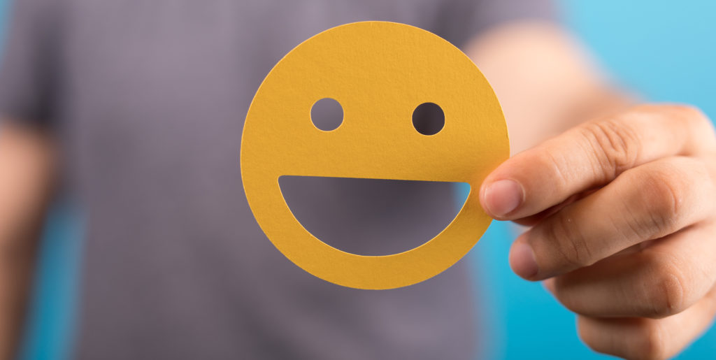 Man shows yellow smiley in the camera.