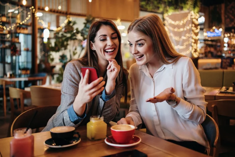Two best friends sitting in coffee bar or restaurant after shopping