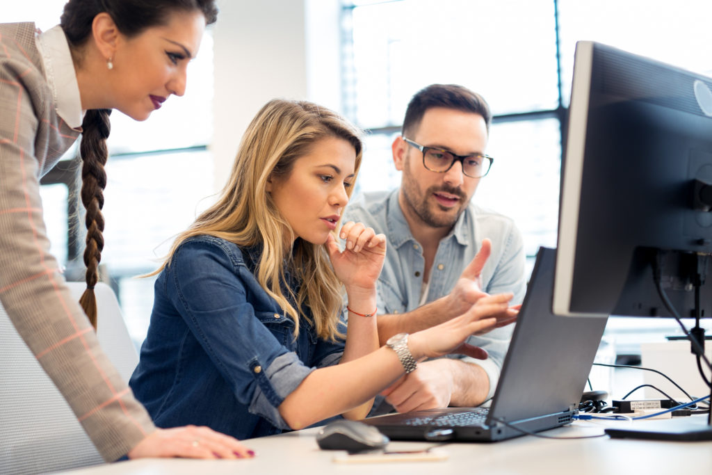 Group of software developers discussing and working as a team in the office.