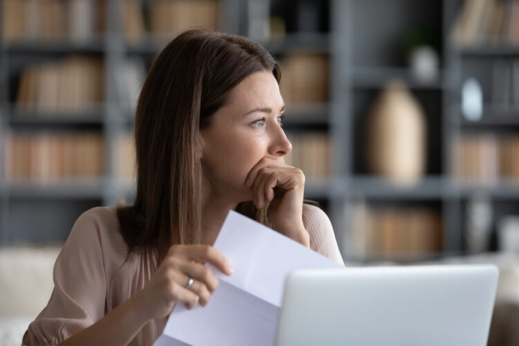 woman holding a document stressed and anxious.