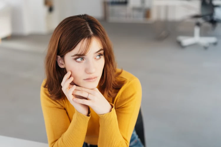 Worried young woman sitting looking aside
