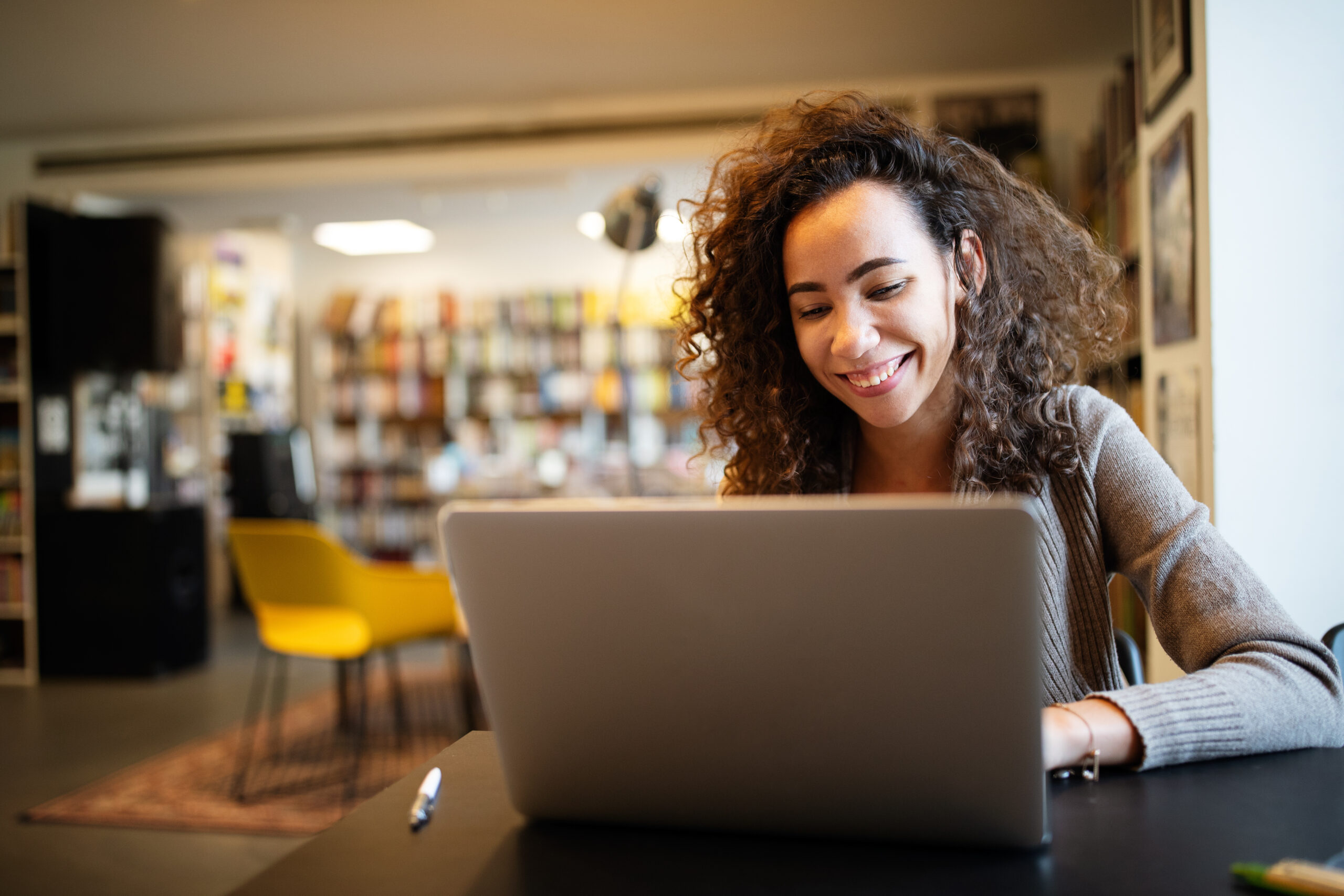 Young beautiful student girl working, learning in college library