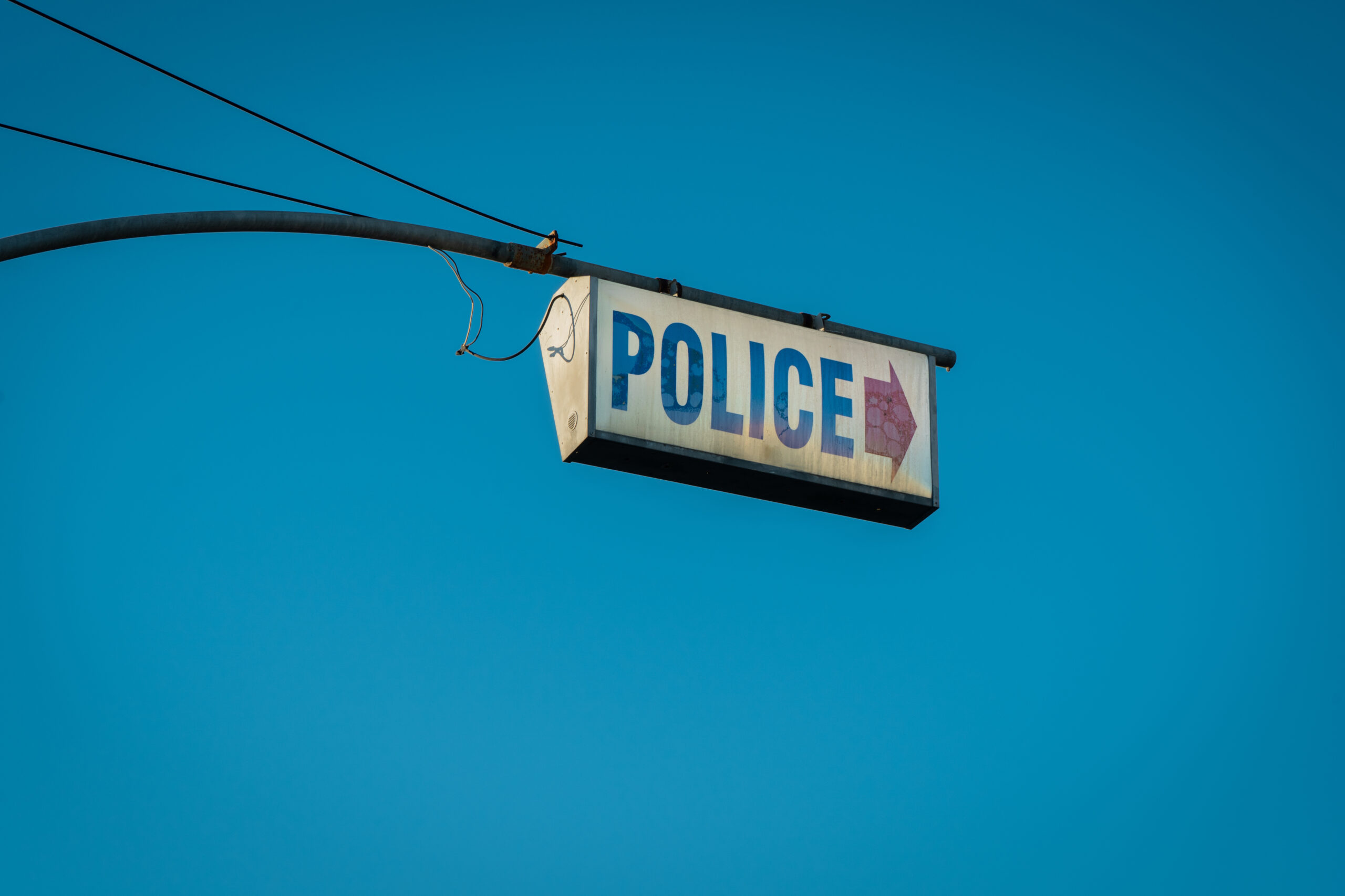 A dirty sign pointing to a police station