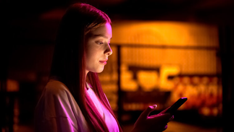 Young woman scrolling web-pages on smartphone