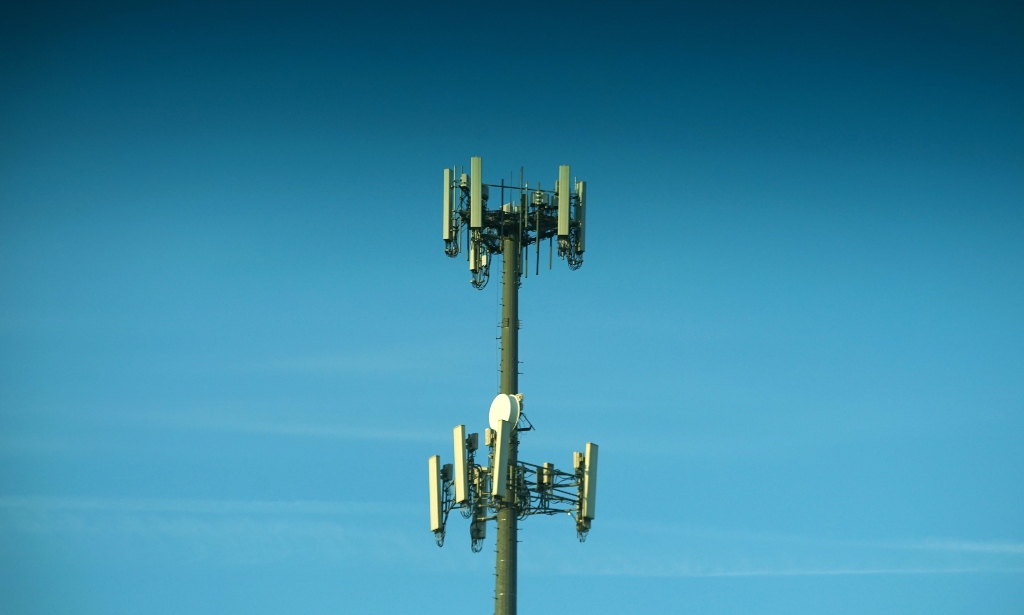 A telecommunications tower against a blue cloudless sky.