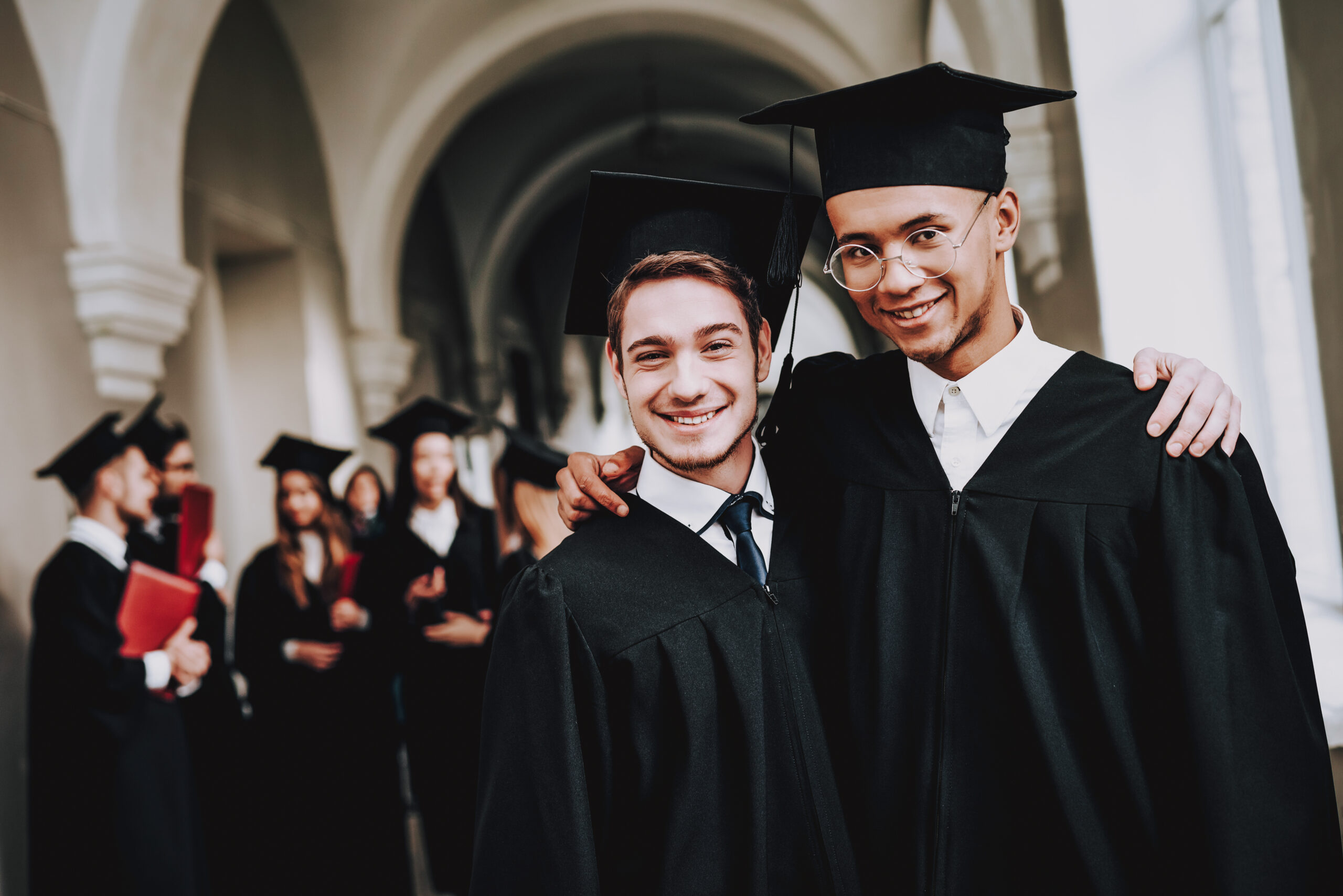 cheerful male university graduates during graduation day