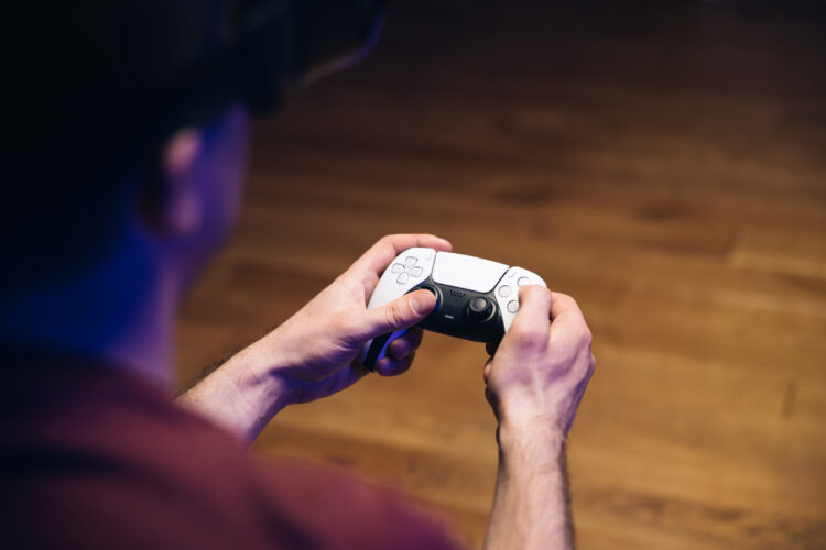 man playing video games on gaming console in front of TV widescreen. 