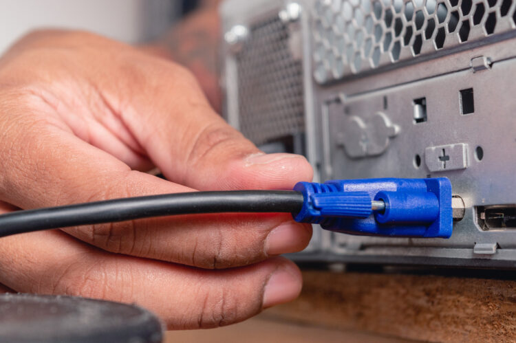 male hand installing VGA cable in a cpu case