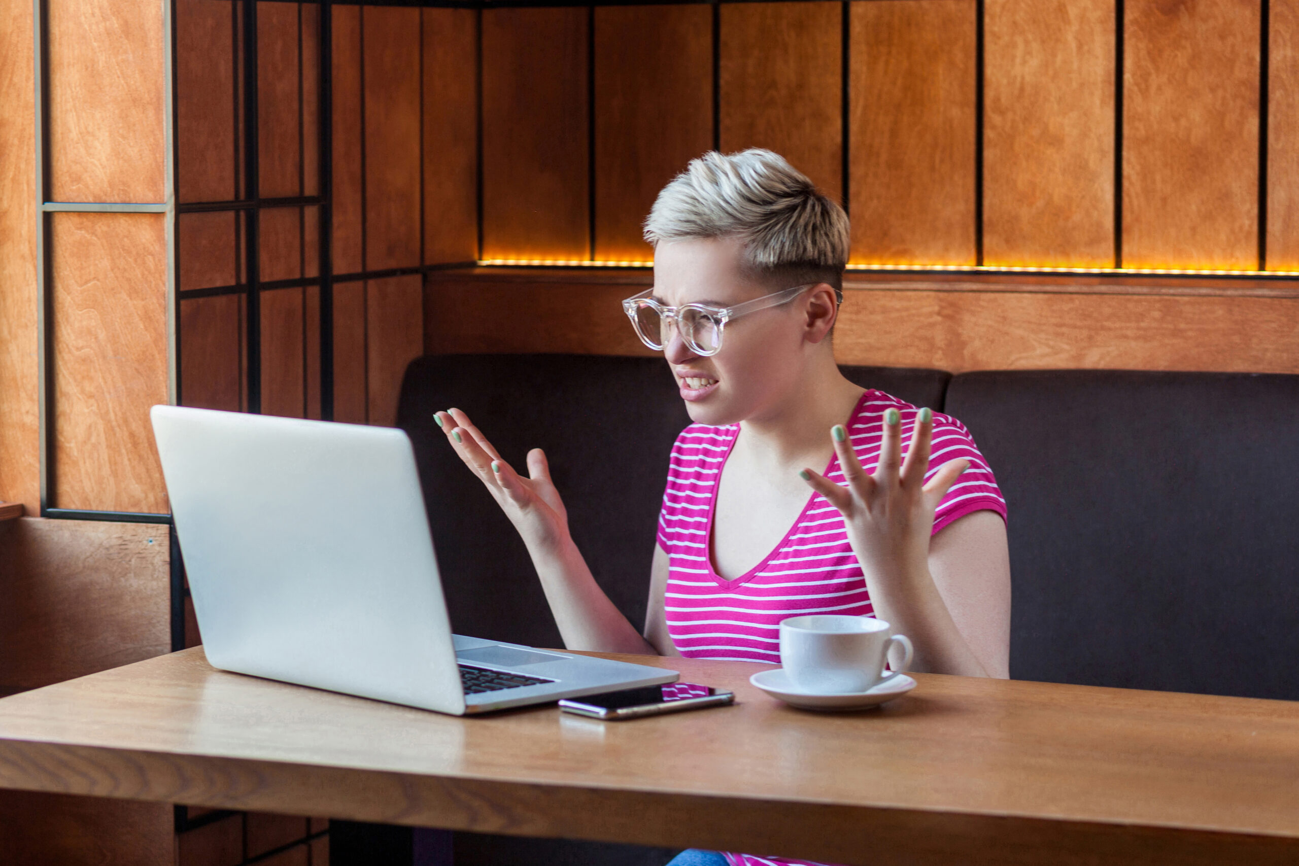 shorthaired blonde annoyed while using laptop