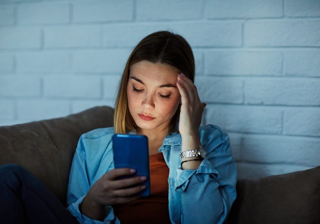 Young woman worried while checking out her phone.