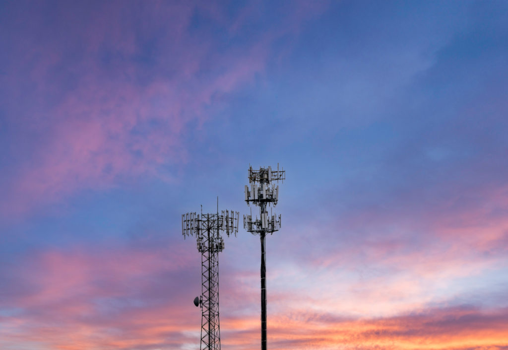Two cellphone towers providing digital service to rural areas at sunset