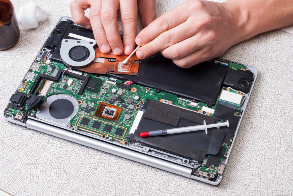 Technician repairs, cleans laptop.