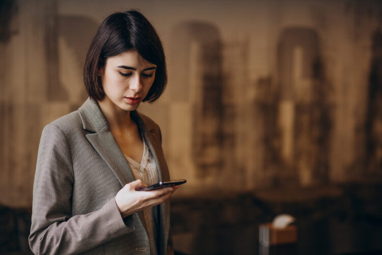 Young business woman using phone in a cafe