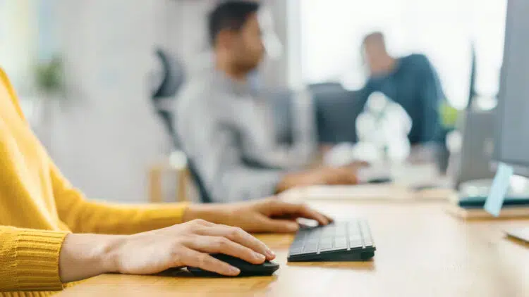 young woman sitting at her desk working on computer