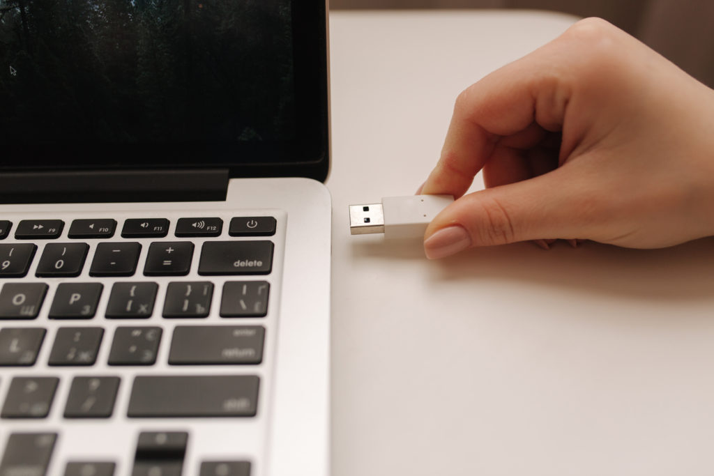 Female hand put USB adapter to copy file from the laptop