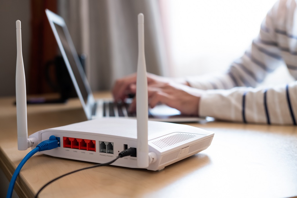 Wireless home router with man working at his desk in the background.