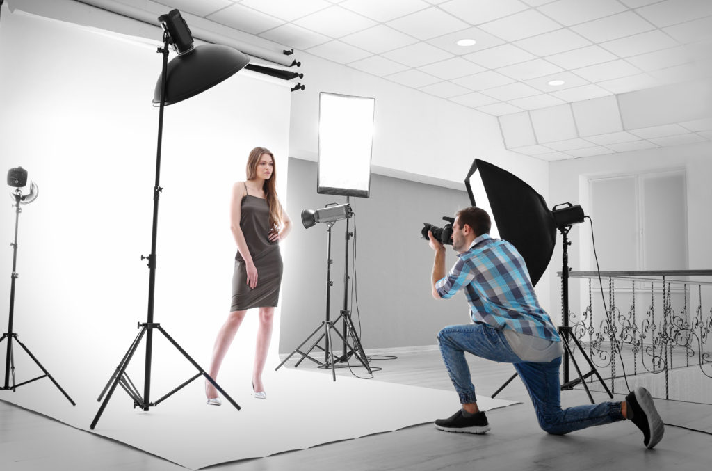 Photographer taking pictures of a model in studio