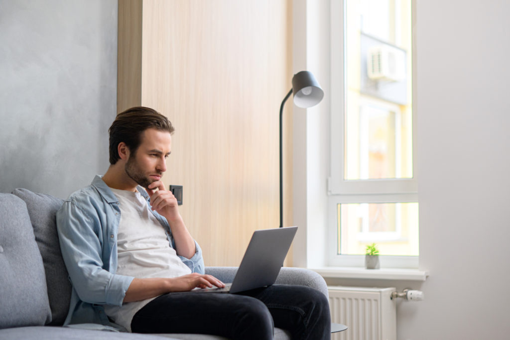 Man concentrating while working on his laptop.