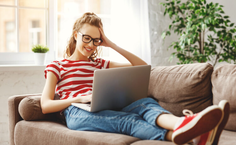 Joyful relaxed woman using laptop at home