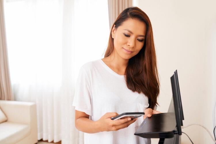 Woman holding the wi-fi router and cell phone
