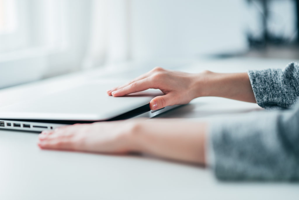 Woman closing or opening a laptop.