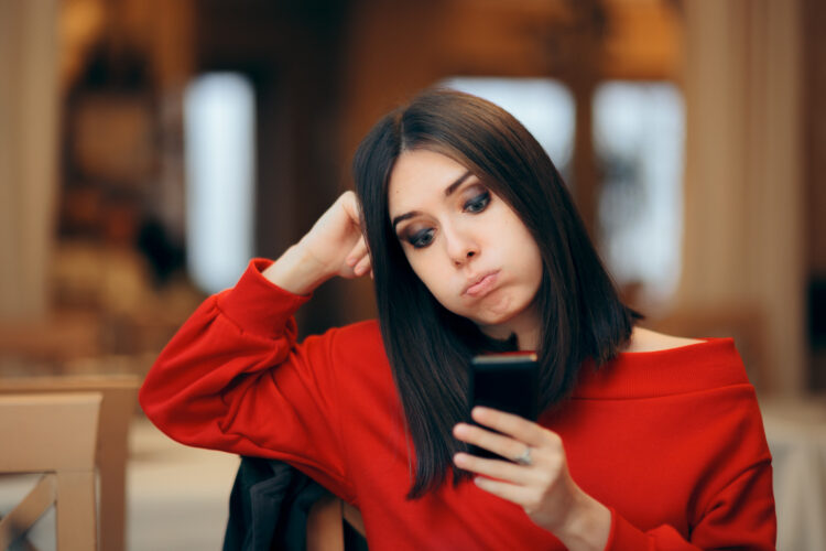 woman looks frustrated using smartphone