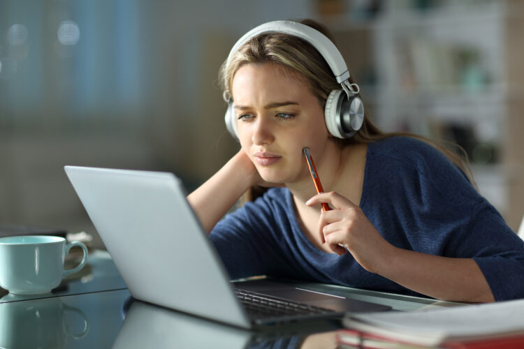 Pensive student e-learning using laptop 