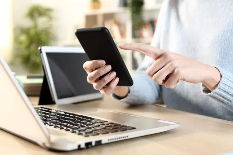 female hands using multiple devices on a desk