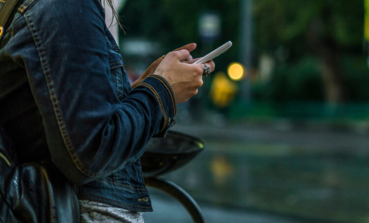 woman using mobile phone in the city on a rainy day