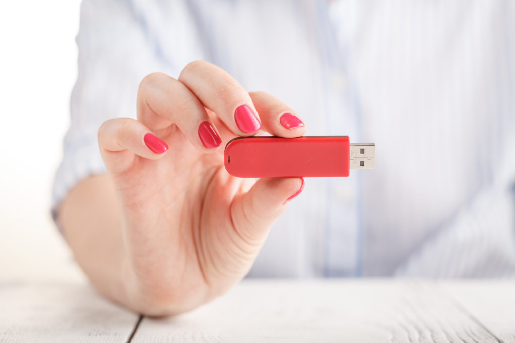 USB flash pen drive in manicured female hand.