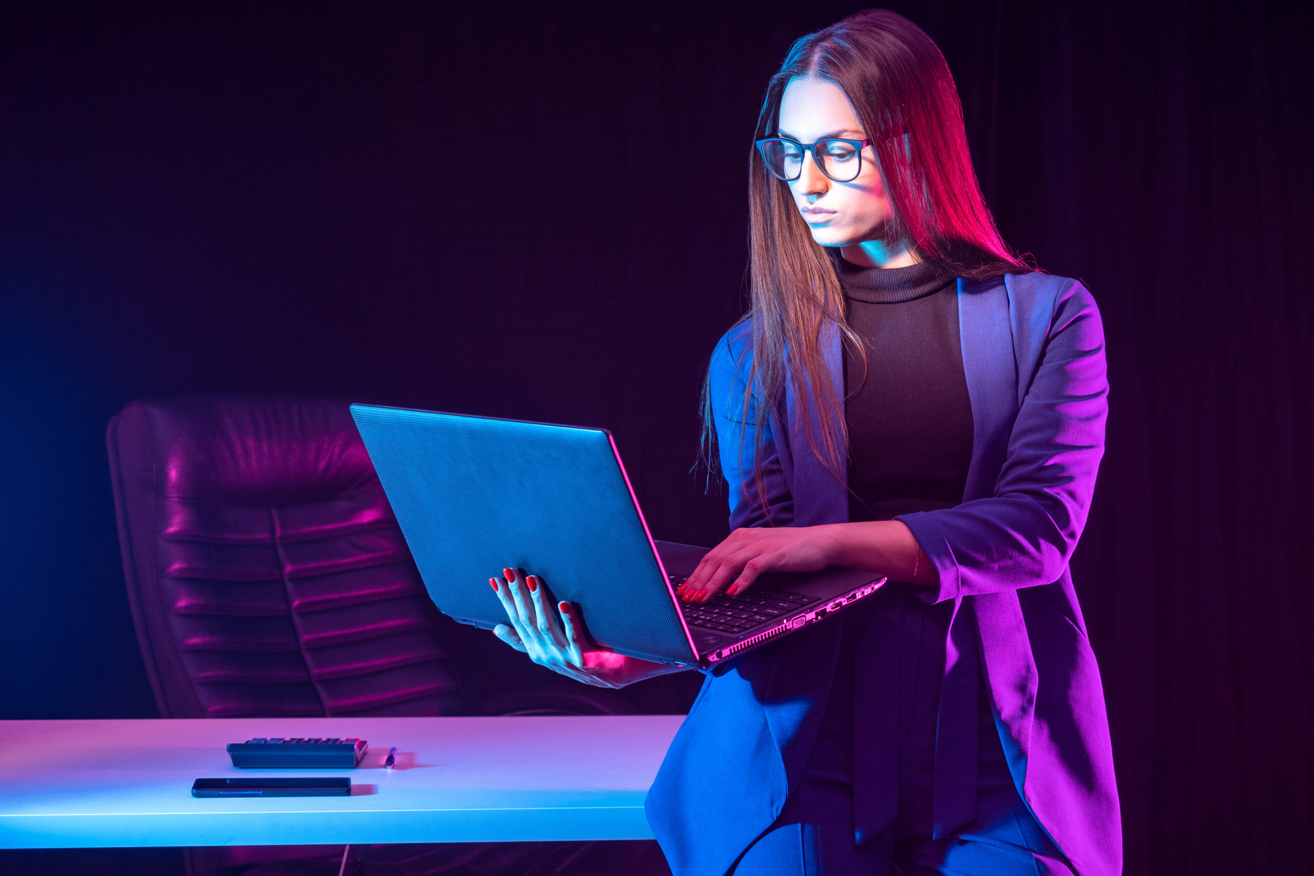 woman with a laptop in a dark room. 