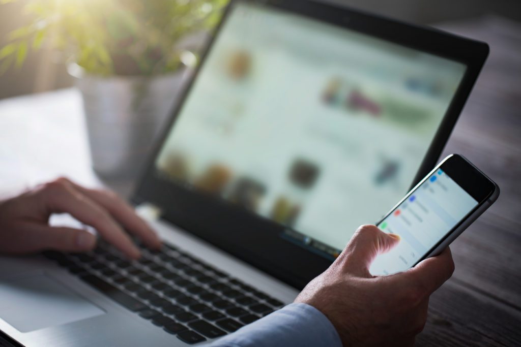 Businessman using both his laptop and phone.