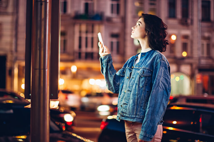 focused girl holding smartphone and looking up