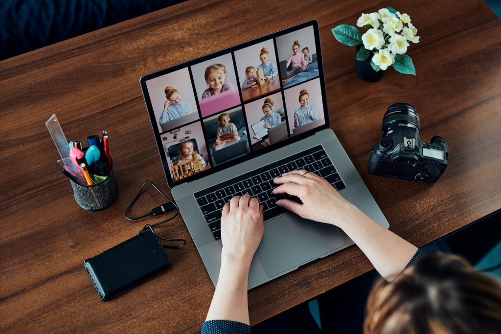 Female photographer working on photos on laptop and camera