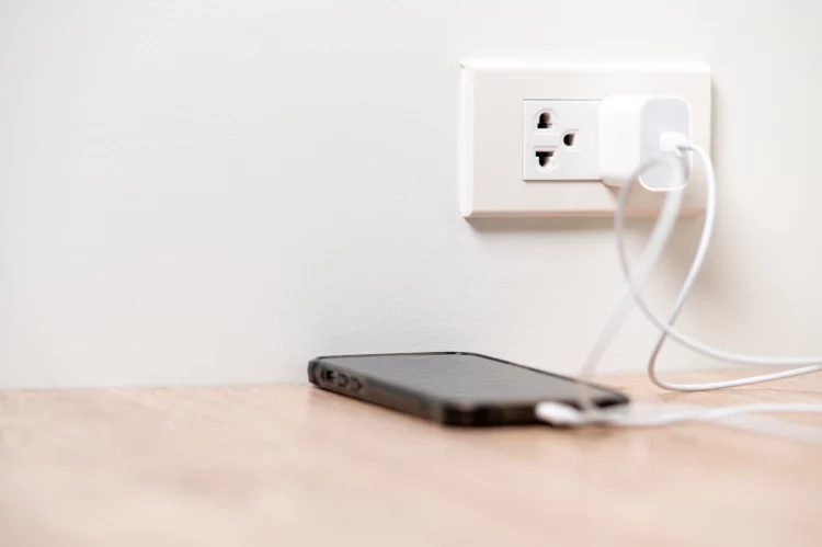 Smart phone charging, plugged into the wall outlet.