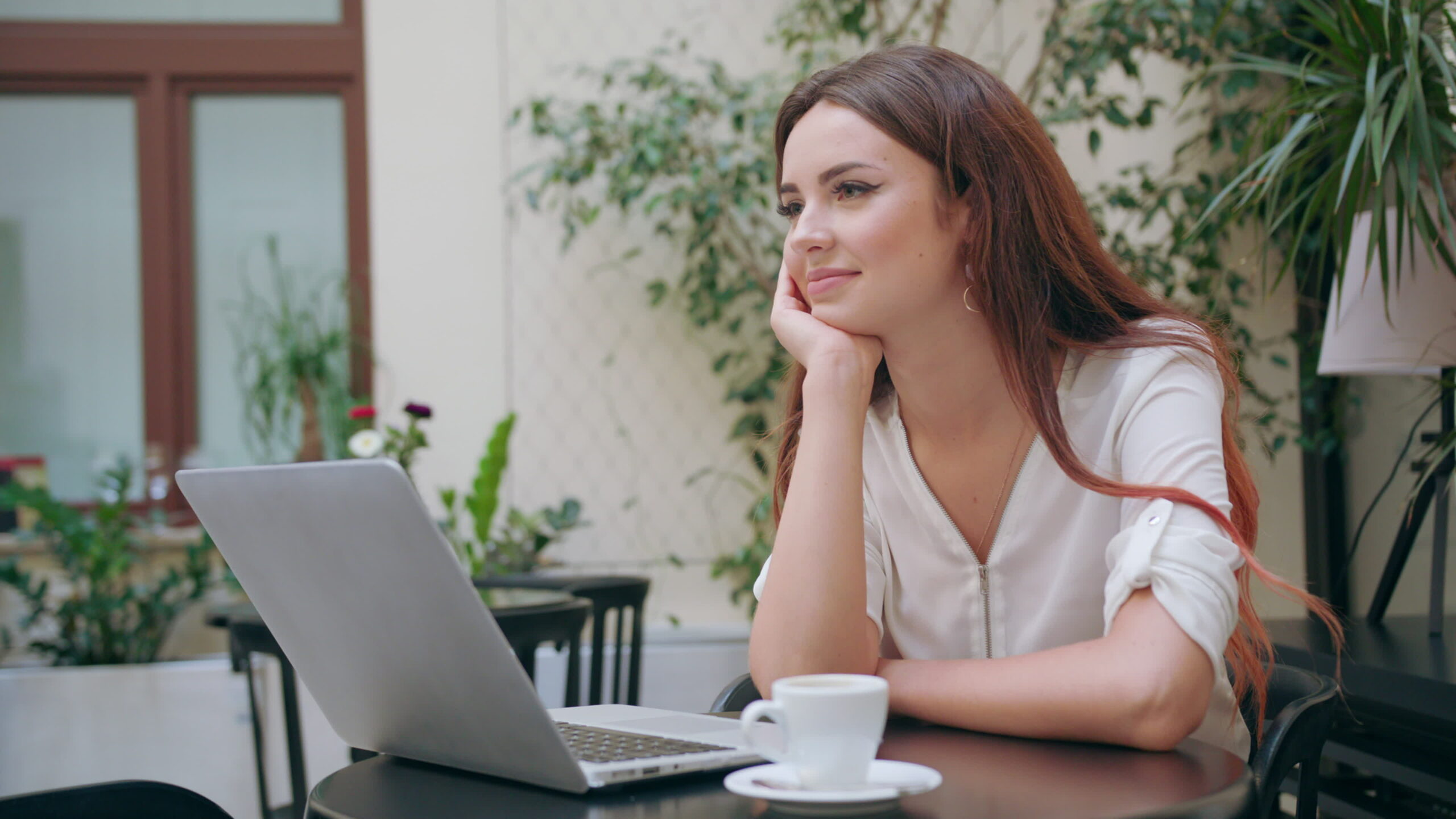 Beautiful young woman sitting at desk with laptop