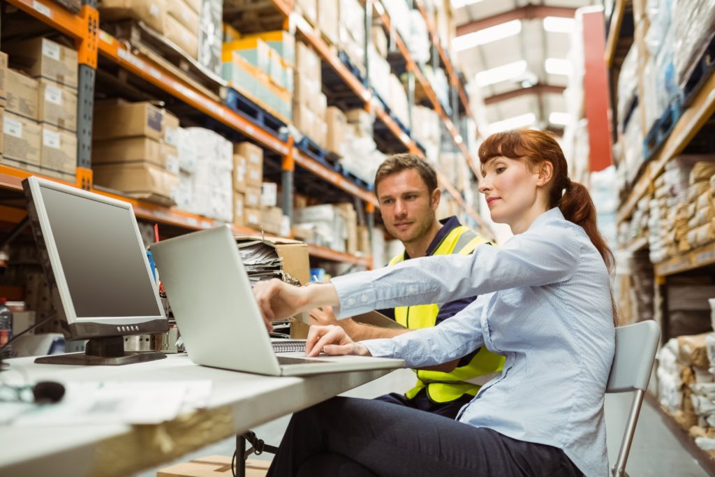 Warehouse staff looking at data and reports.