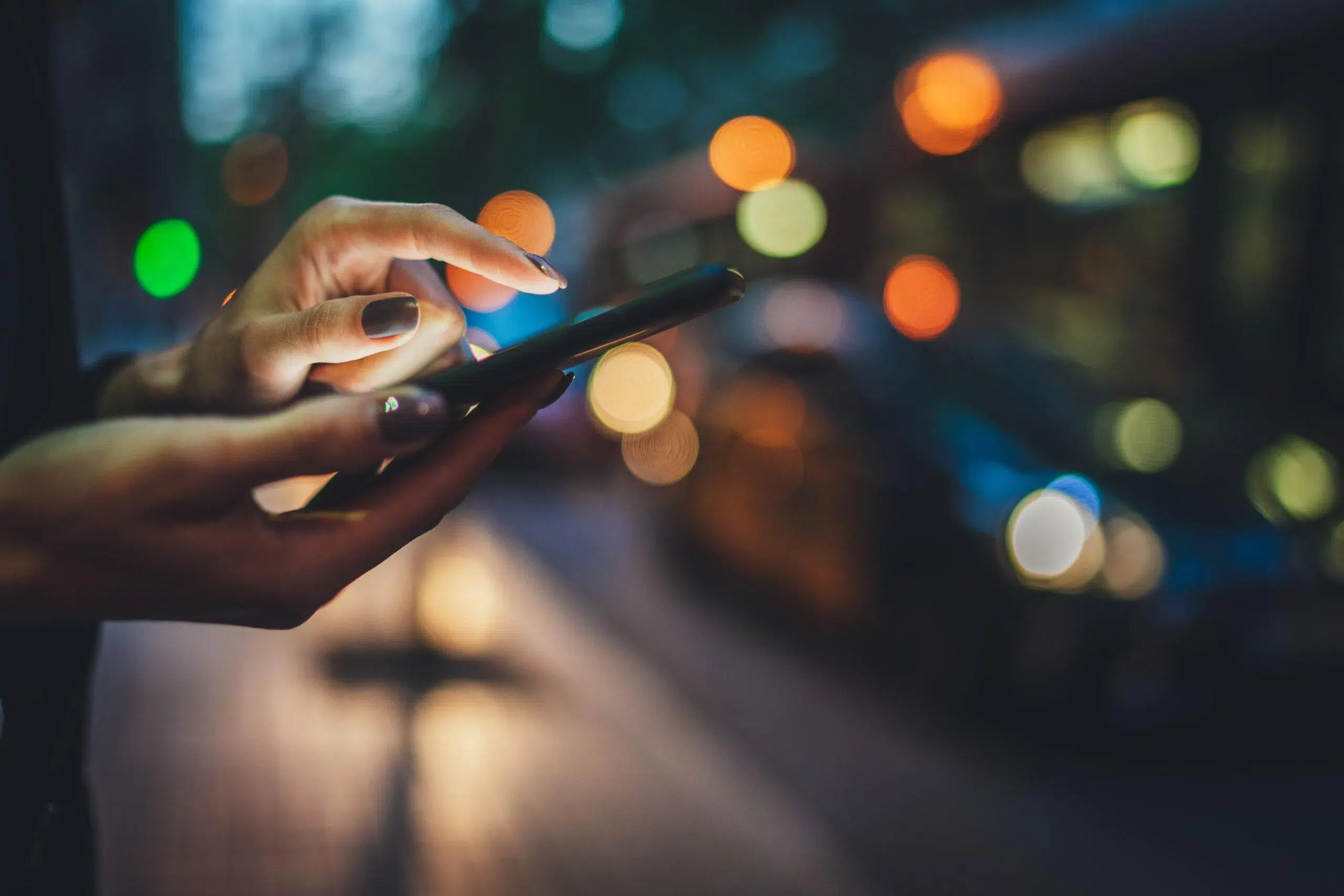 Closeup of female using smartphone trying to discover if you unfollow someone on Instagram will they know.