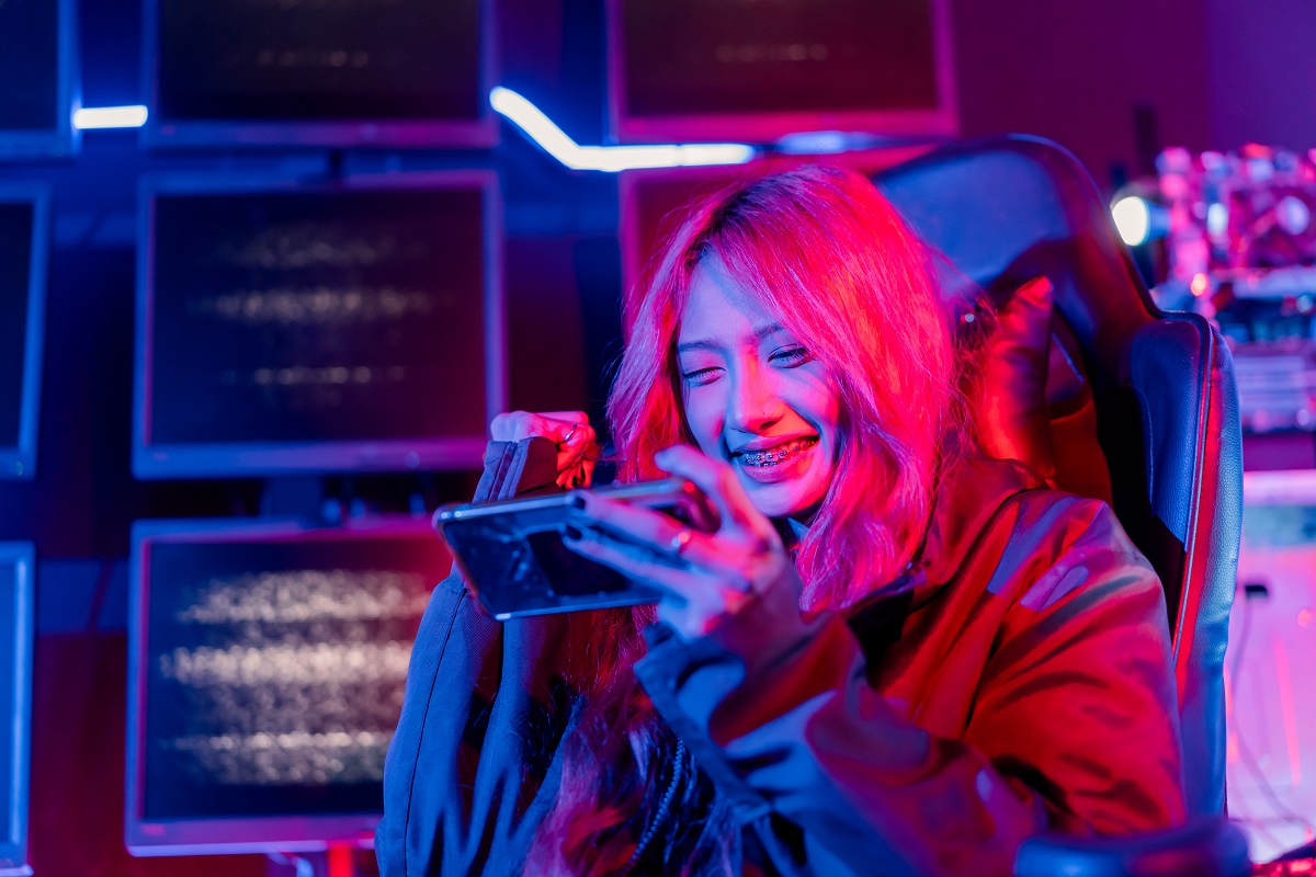 young female gamer plays a game on her mobile device