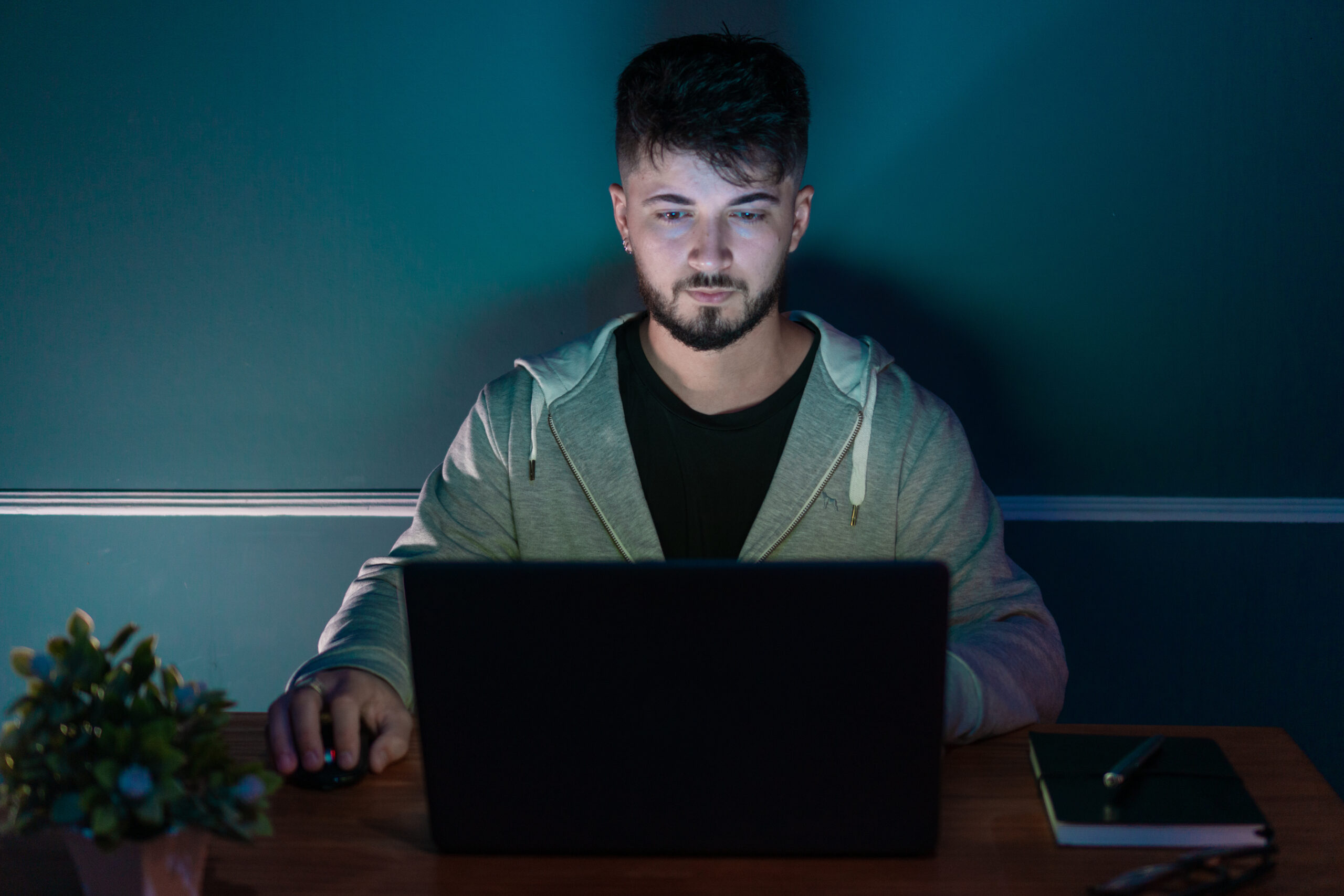 Young man in front of a computer doing work from home. All in a