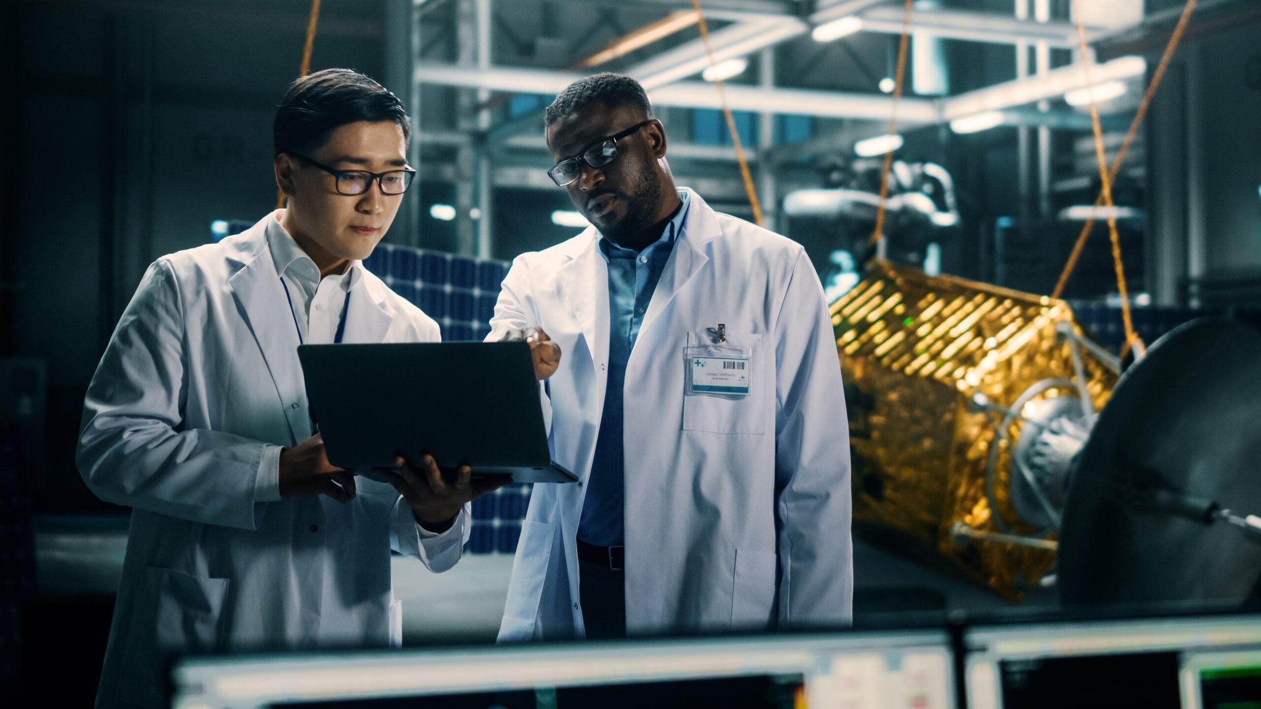 Engineer and technician working together on satellite construction