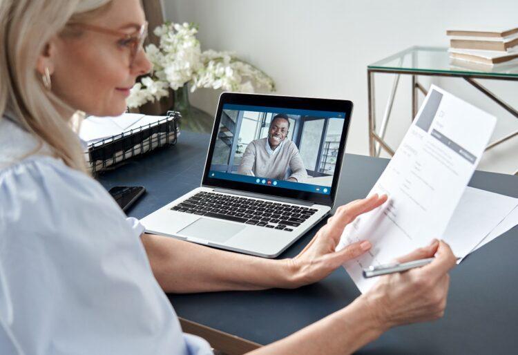 Female hr reading cv during online virtual job interview by video call.
