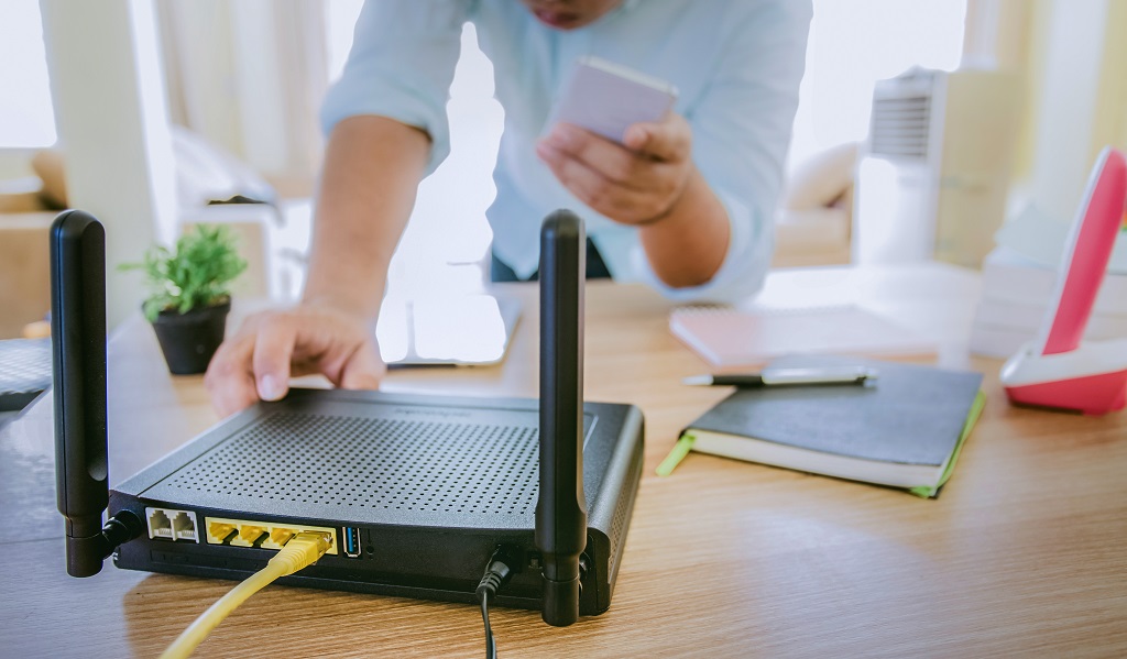 Wireless router and a man using smartphone in the living room.