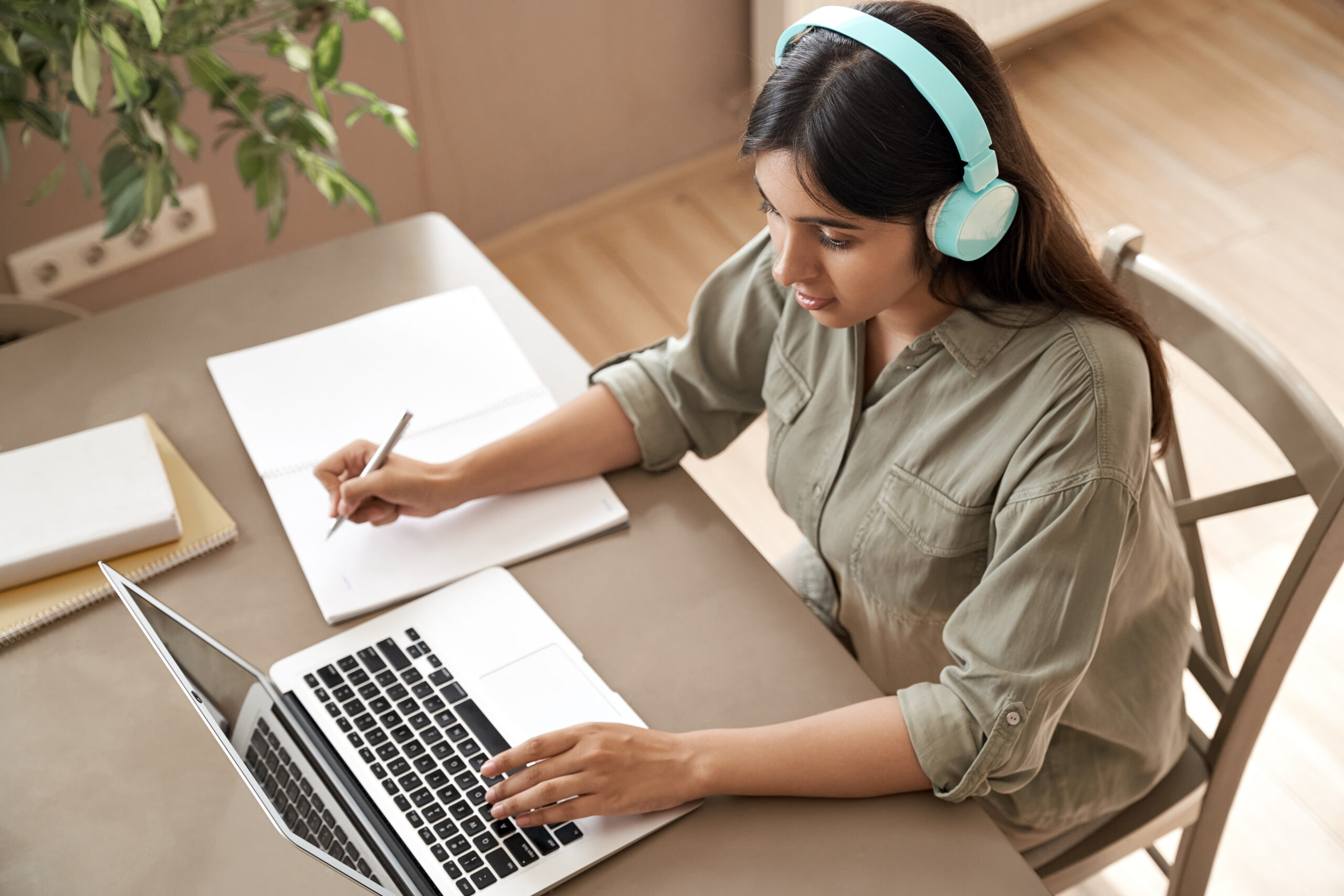 Indian girl student wear headphones watching online webinar class learn at home.