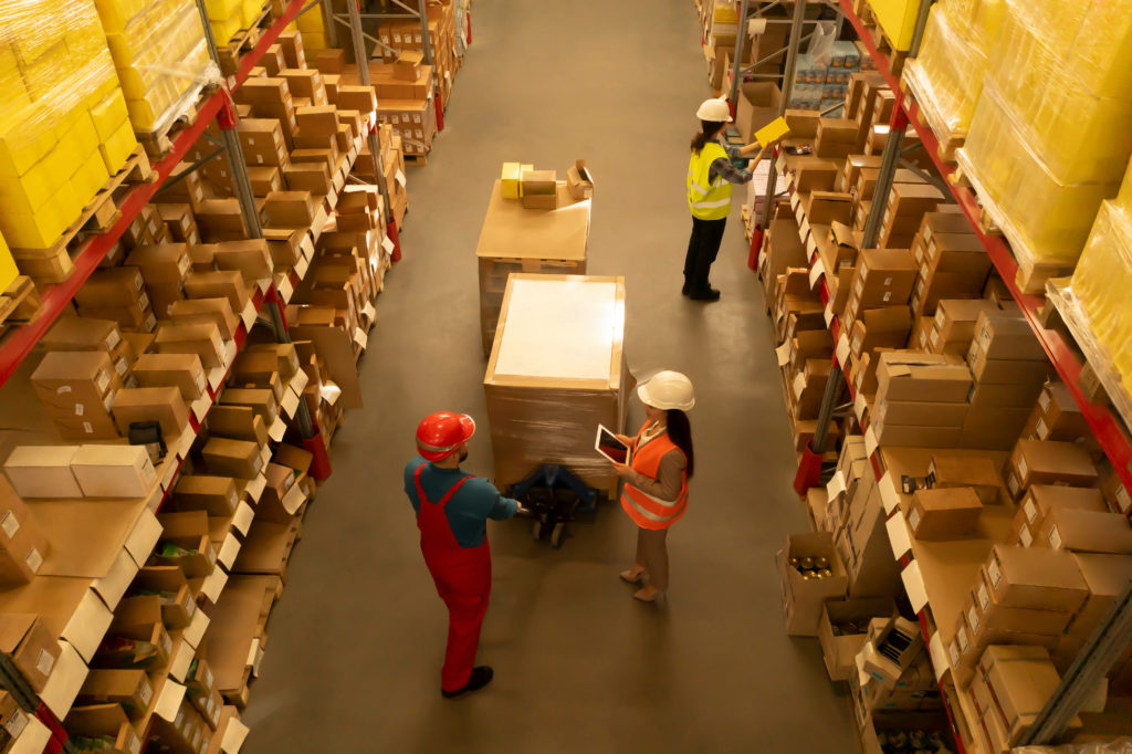 Manager and workers at warehouse of logistics center.