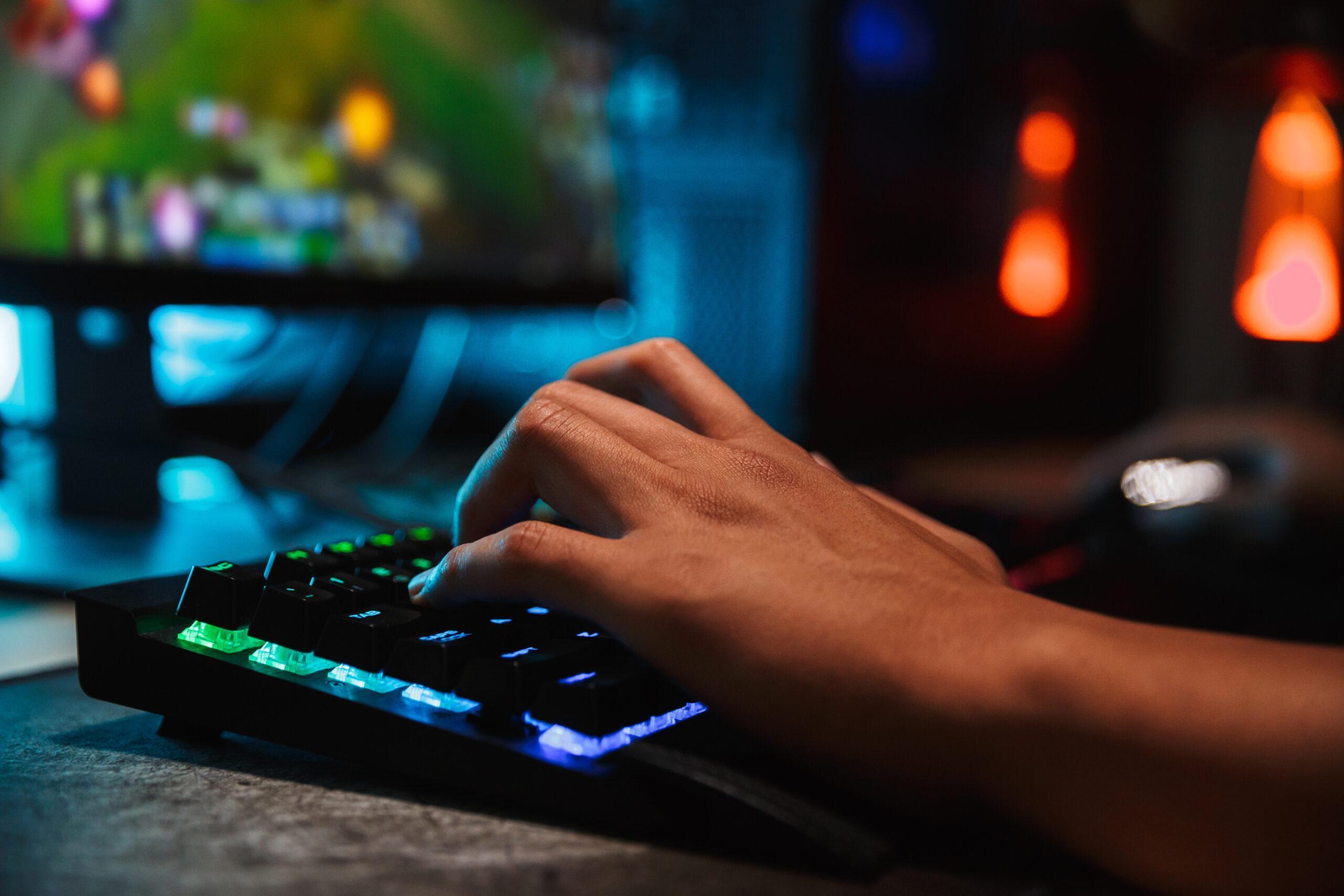Hands of professional gamer playing video games on computer