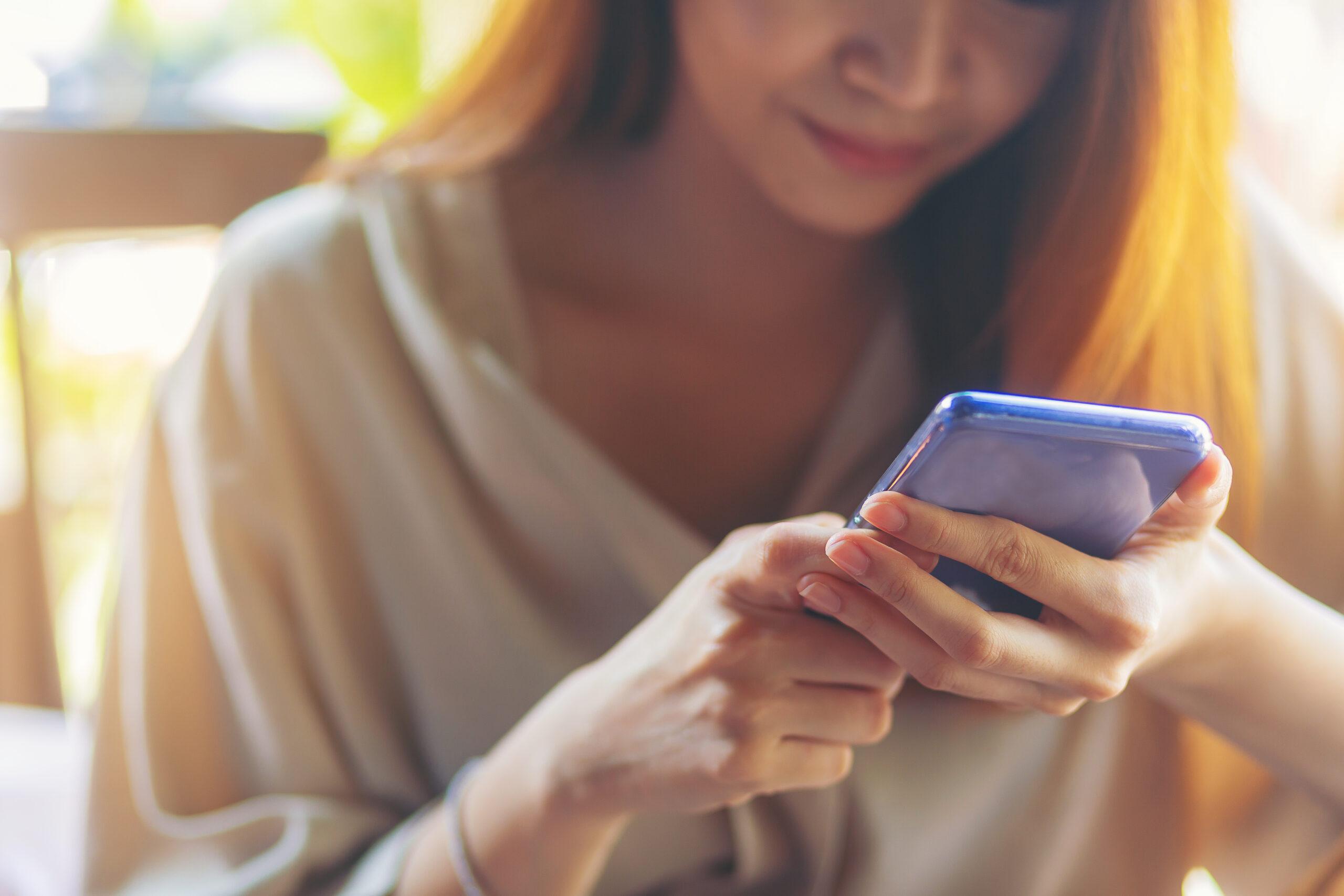 Relaxed woman using smartphone